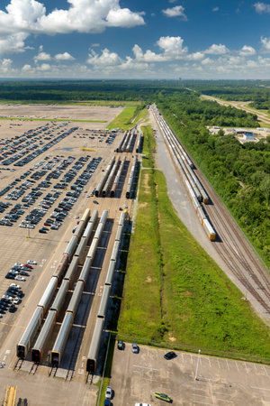 New cars ready for sale on railway cargo train carrier at automotive factory parking lot. Dealer vehicle inventory for import and exportの写真素材