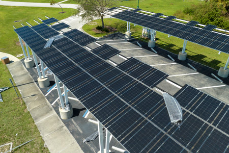 Damaged by hurricane wind photovoltaic solar panels mounted on parking lot canopy roof for producing...