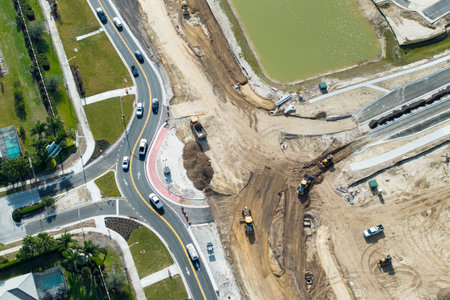 Industrial construction roadworks at roundabout intersection with moving cars in Venice, Florida. Development of urban circular transportation crossroads.の写真素材