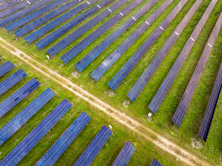 Industrial solar energy facility with uniform rows of panels converting sunlight into renewable electricity. Focus on sustainable development and emission-free energy generationの写真素材