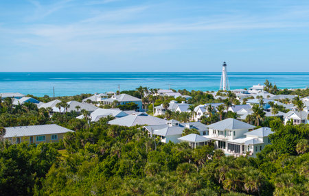 Rich neighborhood with expensive vacation homes and white lighthouse on ocean shore in Boca Grande, small town on Gasparilla Island in southwest Florida. Wealthy waterfront residential areaの写真素材