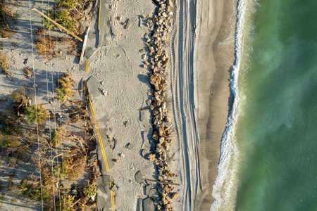 Road erosion after hurricane in Florida. Storm surge washed away asphalt on Manasota Key road at Blind Pass Beach. Severe damage to waterfront infrastructureの写真素材