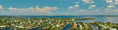 Aerial view of rural private houses in remote suburbs located on sea coast near Florida wildlife wetlands with green vegetation on gulf bay shore. Living close to nature in tropical region conceptの写真素材