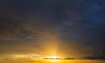 Beautiful sunset sky scenery. Bright colorful orange and yellow clouds on horizonの写真素材