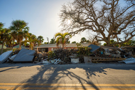 Consequences of natural disaster. Trash from severely damaged houses after hurricane storm surge. Piles of debris on street side in Floridaの写真素材