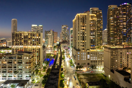 Elevated train system through Brickell district in Miami, Florida with city skyscrapers illuminated public transportation networkの写真素材