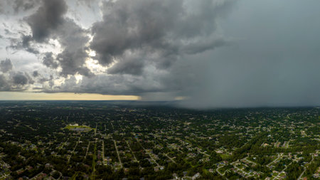 Heavy rain falling down from stormy clouds over rural Florida suburbs. Thunderstorm on dark sky....