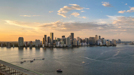 Miami, Florida. Fishing and recreational yachts and boats sailing in Biscayne Bay harbor. Sunset over city skyline with high-rise buildings in downtownの写真素材