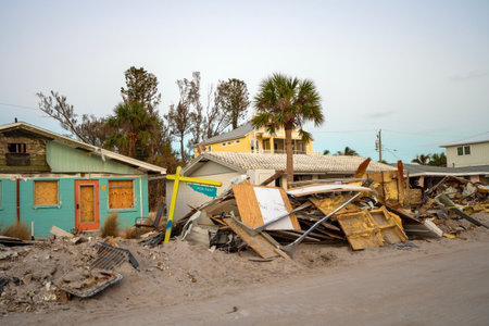 Piles of debris on street side after hurricane Milton on Manasota key road in Florida. Trash from severely damaged houses after storm surge. Consequences of natural disasterの写真素材