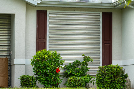 Storm shutters mounted on Florida house windows for hurricane protection. Preparing for natural disasterの写真素材