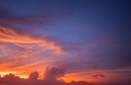 Sunset sky with bright colorful orange and yellow clouds. Panoramic skyscapeの写真素材