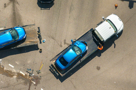 Traffic accident with tow truck hauling smashed vehicle on car crash site. First responders helping on road emergency in Floridaの写真素材