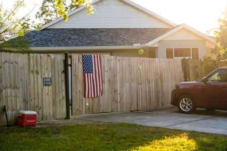 Wooden picket fence on green lawn surrounding property grounds for backyard protection and privacy