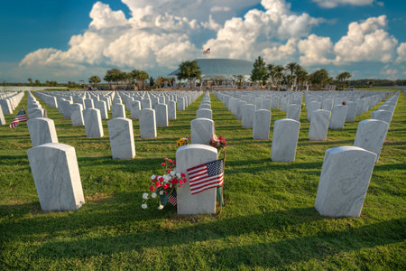 Army veteran cemetery with white headstones and USA flag. Tombs of retired military soldiers....