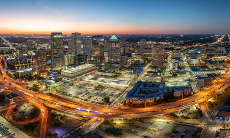 American city skyline of Tampa in Florida. Brightly illuminated commercial buildings and high speed highway road. Night urban landscape of downtown district in USA.の写真素材