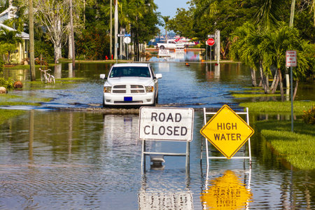 Hurricane Milton flooded street with road closed sign blocking driving of cars in Punta Gorda, Florida. Safety of transportation during natural disaster conceptの写真素材