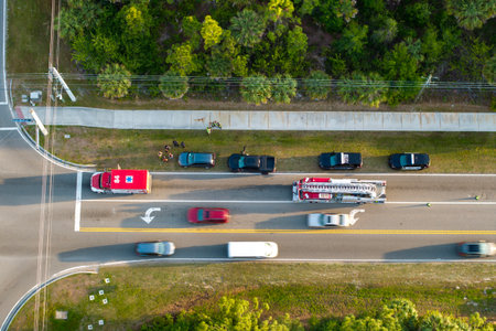 Traffic accident on American street in Florida. First responders helping victims of car crash on...