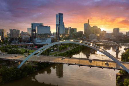 Downtown district of Nashville city in Tennessee, USA at sunset. Cars drive on Korean Veterans...