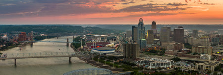 Aerial view of downtown district highway traffic in Cincinnati city, Ohio at sunset. Brightly...