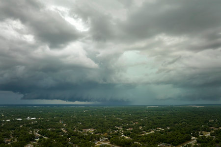 Landscape of dark ominous clouds forming on stormy sky before heavy thunderstorm over rural town...
