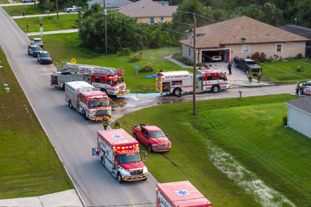 First responders at potential fire hazard at Florida home. Firefighter trucks at fire alarm scene of...