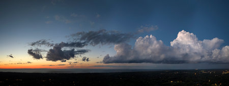 Colorful sunset sky over rural area. Setting sun behind vivid orange and yellow cloudsの写真素材