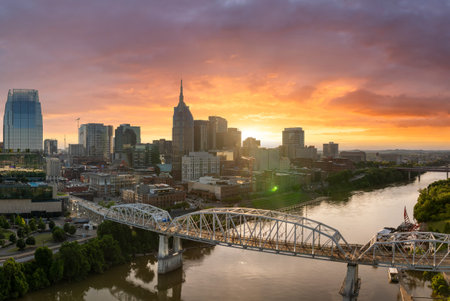 Downtown district of Nashville city in Tennessee, USA. Modern metropolitan area with riverfront, bridge and sunset horizon.の写真素材