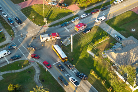 Traffic crash with damaged school bus and car on USA city street
