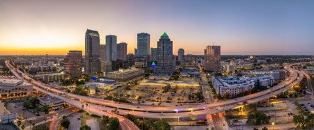 Tampa, Florida. Cars traffic driving on wide highway and high skyscraper buildings in downtown district. American city with business financial district at nightfall.の写真素材