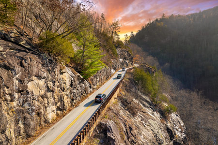 Highlands Road mountain highway in North Carolina during fall. Vehicle driving through forested...