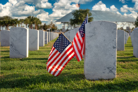 Military burial headstones. Sarasota National Cemetery with rows of white tomb stones and USA flags on green grass. Memorial Day conceptの写真素材