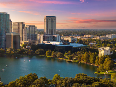 Elevated view of Orlando, Florida with financial district surrounding Lake Eola. Contemporary architecture blends with waterfront scenery and lush green landscape.