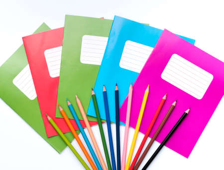 Colorful school exercise books and drawing pencils on white background.の写真素材