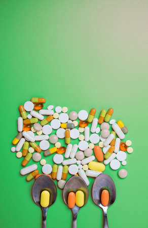 Close up of many different pills on green background.の写真素材