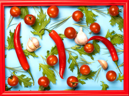 Red chili peppers, garlic, tomatoes and green rucola salad leaves background.の写真素材