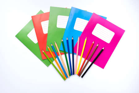 Colorful school exercise books and drawing pencils on white background.の写真素材