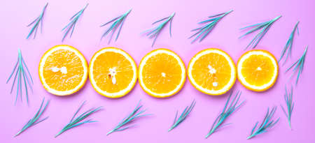 Flat lay view of orange slices on pink backround.