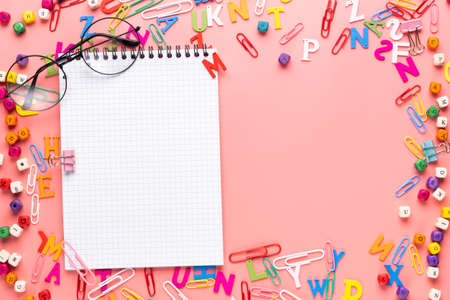 Many different school supplies and empty notepad white sheet of paper on copy space background. Back...