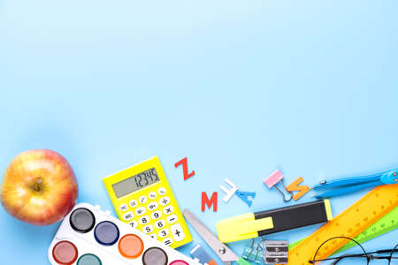 Many different school supplies on blue copy space background. Back to school concept.の写真素材