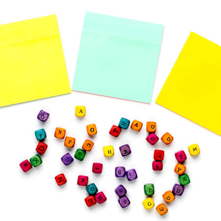 Set of colorful note stickers and latin alphabet letters on white background.