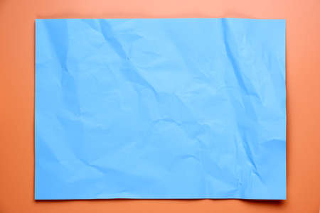 Close up of blue crumpled empty sheet of paper on orange background.の写真素材