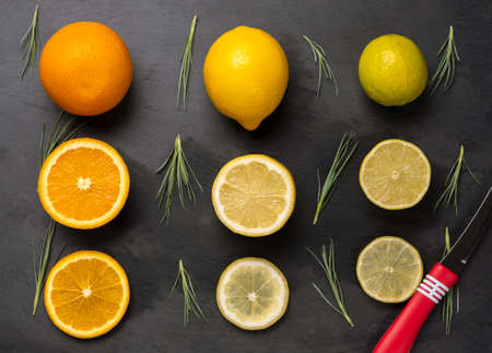 Close up of sliced citrus fruits orange, lemon and lime on dark black background.の写真素材