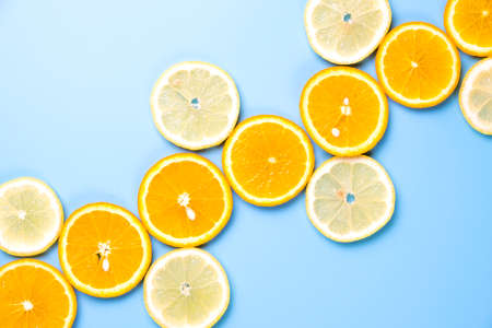 Flat lay view of orange and lemon slices on blue backround.の写真素材