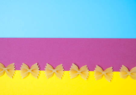 Close up pattern of noodles farfalle also known as bow-tie or butterfly pasta placed on colorful background.の写真素材
