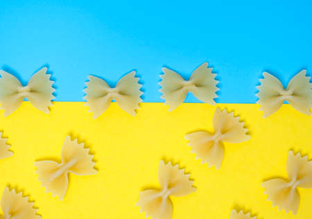 Close up pattern of noodles farfalle also known as bow-tie or butterfly pasta placed on colorful background.の写真素材