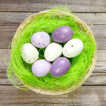 easter nest with easter eggs on wooden background の写真素材