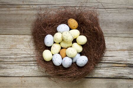 Brown nest with easter eggs on rustic wood の写真素材