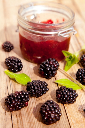 Blackberry jam and fresh blackberries on the wooden table 