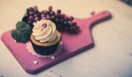 Sweet Cupcake with sugar hearts and grapes