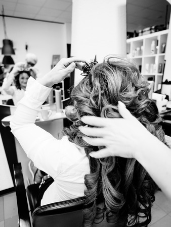 Hairdresser styling customers hair at a salonの写真素材
